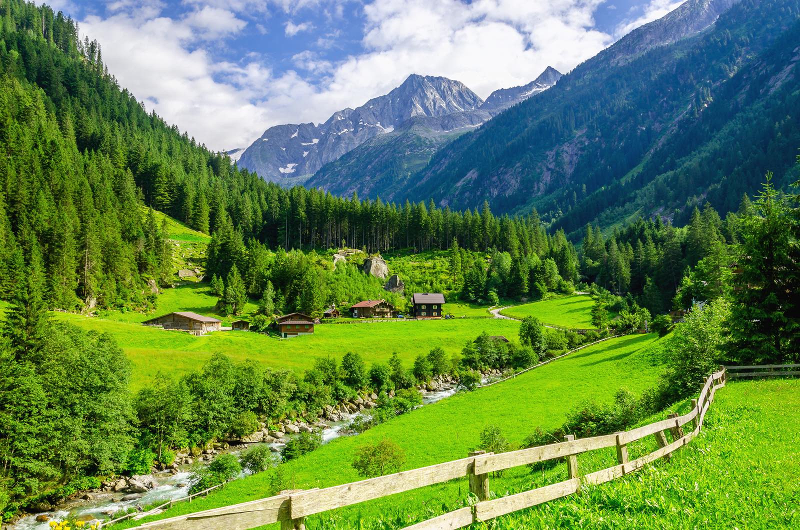 Green meadows, alpine cottages and mountain peaks