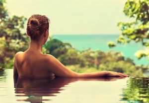 Beautiful girl rests in the swimming pool , sunbathing.