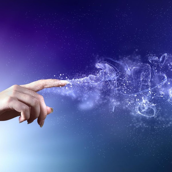 magical hand conceptual image with sparkles on colour background